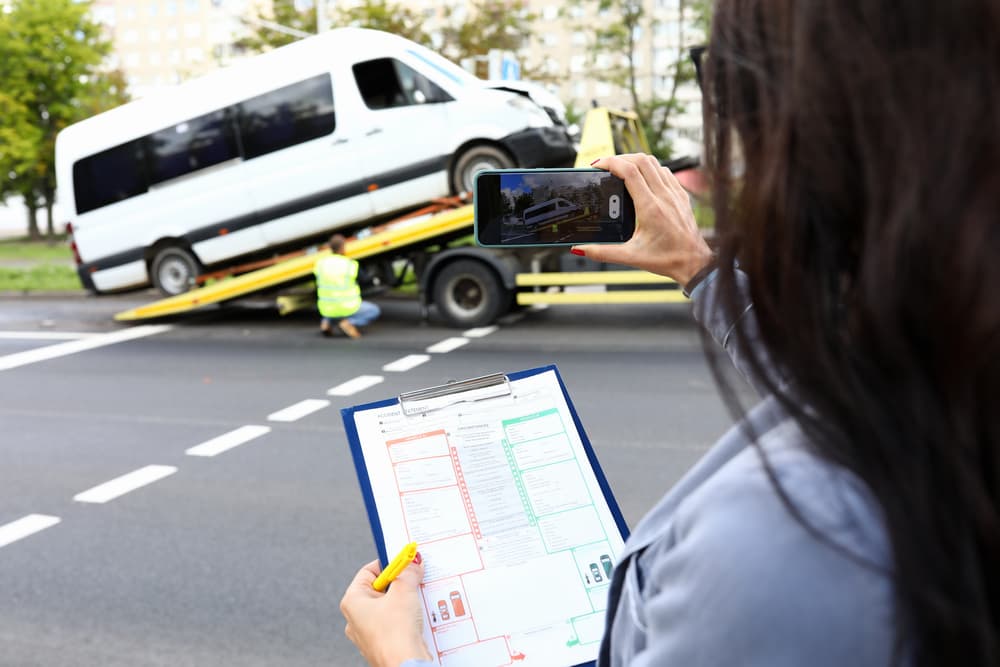 Insurance agent records accident on her phone and evaluates damages